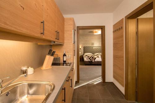 kuchnia ze zlewem i łóżkiem w pokoju w obiekcie Gurglhof Apartmenthaus w mieście Obergurgl