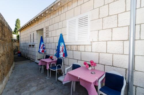 two tables and chairs with umbrellas on a patio at Guest House Curic in Dubrovnik