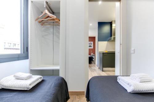 a bedroom with two beds and a walk in closet at Nicebarcelonaapartments in Barcelona