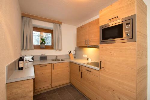 a small kitchen with a sink and a microwave at Gurglhof Apartmenthaus in Obergurgl