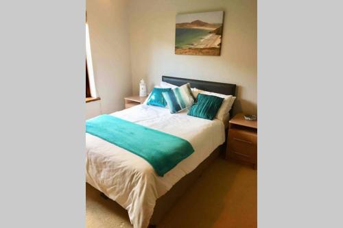 a bedroom with a large bed with blue pillows at Parkwood House in Dungannon