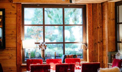 a room with a table with red chairs and a window at Hotel Le Castel in Chamonix-Mont-Blanc