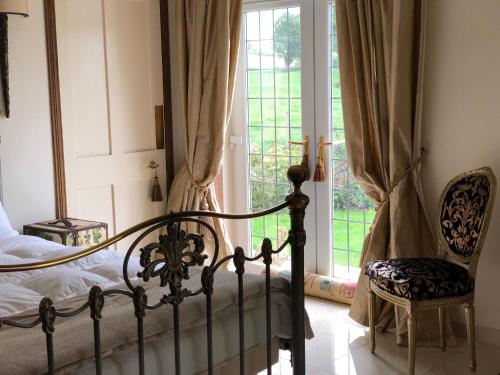 艾爾的住宿－Retreat at The Knowe Auchincruive Estate，卧室配有床、椅子和窗户。