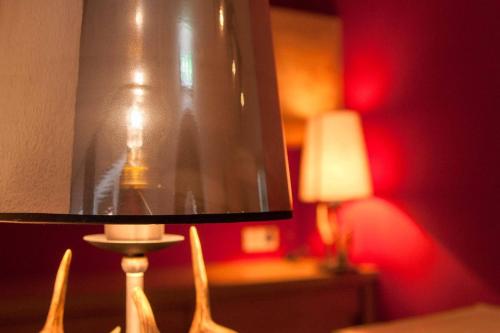 a lamp in a room with a red wall at Gurglhof Apartmenthaus in Obergurgl