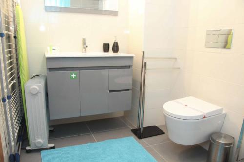 a bathroom with a white toilet and a sink at Carmona - By SCH in São Martinho do Porto