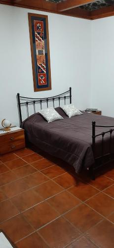 um quarto com uma cama preta com almofadas em Casa da Passagem em Vila Real