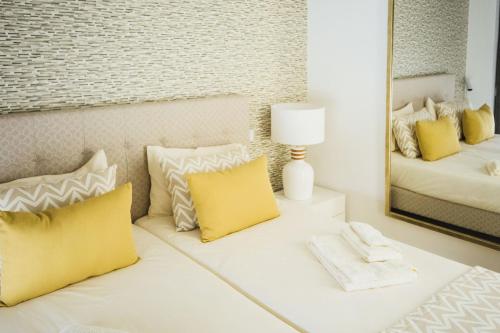 a bedroom with yellow pillows and a mirror at Estrela de Salir - Holiday - By SCH in Salir de Porto