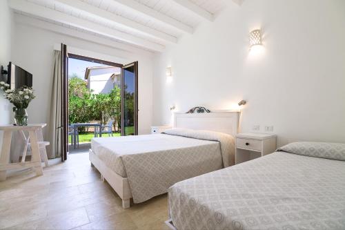 a hotel room with two beds and a large window at Hotel Vecchia Marina in Àrbatax