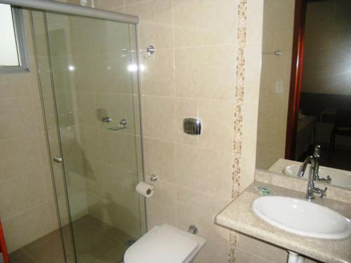 a bathroom with a shower and a toilet and a sink at Hotel São Paulo in Rondonópolis