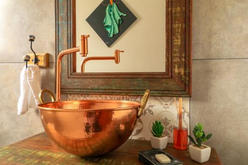 a bathroom with a copper bowl and a mirror at Pousada Catamara in Arraial d'Ajuda