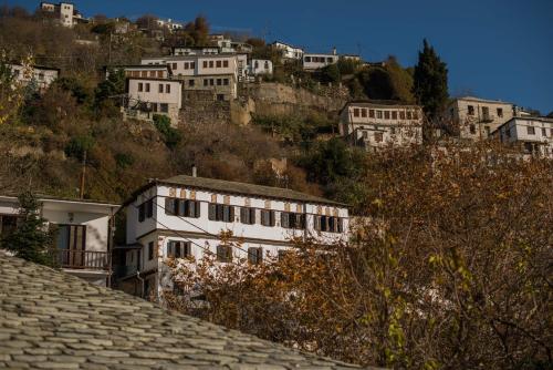 a group of white buildings on a hill at Charis Guesthouse in Makrinítsa