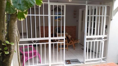 a white cage in a room with a table at Grand F2, spa, jardin, parking in Schœlcher