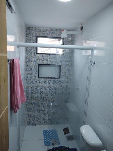 uma casa de banho com um chuveiro e uma televisão na parede em Blue sky House em Búzios