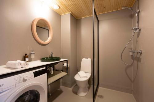 La salle de bains est pourvue d'un lave-linge et de toilettes. dans l'établissement Lietsu Boutique Aparthotel - Huoneistohotelli Lietsu, à Joensuu