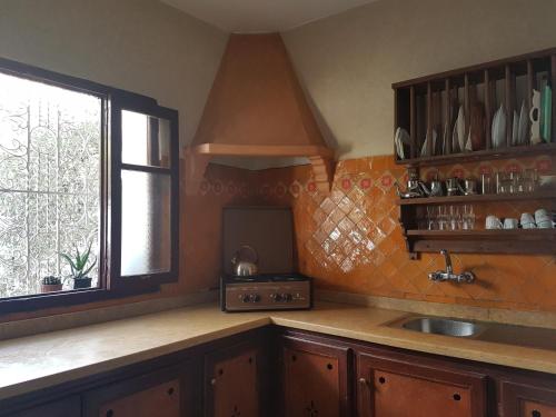 a kitchen with a sink and a window at Maison d'hôte Bousaid in Chefchaouene