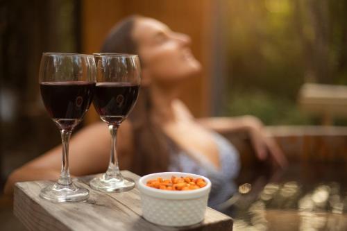 two glasses of wine and a bowl of food on a table at La Escondida Pucon in Pucón
