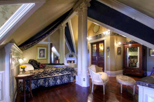 1 dormitorio con 1 cama, mesa y sillas en Gingerbread Mansion, en Ferndale