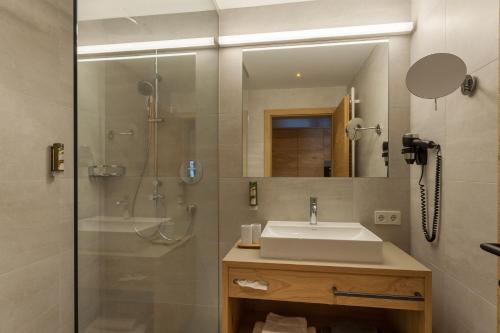 a bathroom with a sink and a shower at Apart-Hotel Dreisonnenhof in Fiss