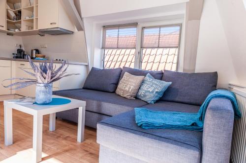 a living room with a blue couch and a table at Top Of The City in Amsterdam