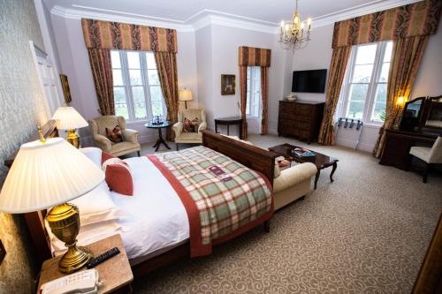 a bedroom with a large bed and a large window at Macdonald Pittodrie House in Chapel of Garioch
