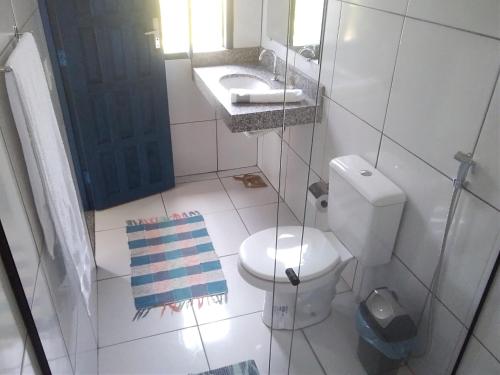 a bathroom with a toilet and a sink and a mirror at Hospedaria Cosanostra in Itaúnas