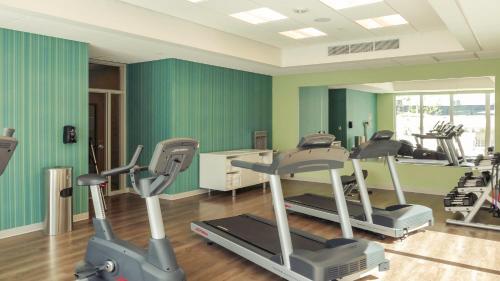 a gym with exercise equipment in a room with green walls at Holiday Inn Express & Suites Miami Airport East by IHG in Miami