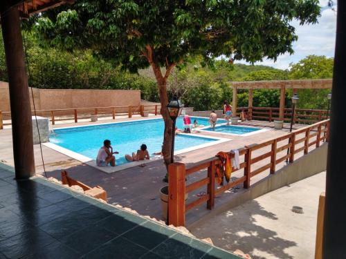 a group of people sitting in a swimming pool at Pousada Portalcion in Goiás