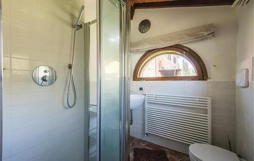 a bathroom with a shower and a toilet and a window at Cottage Le Pozze in Sinalunga