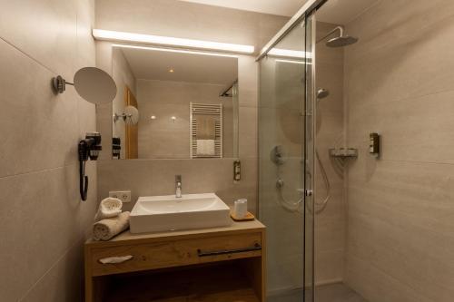 a bathroom with a sink and a shower at Apart-Hotel Dreisonnenhof in Fiss
