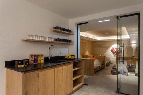 a kitchen with a sink and a glass shower at Apart-Hotel Dreisonnenhof in Fiss