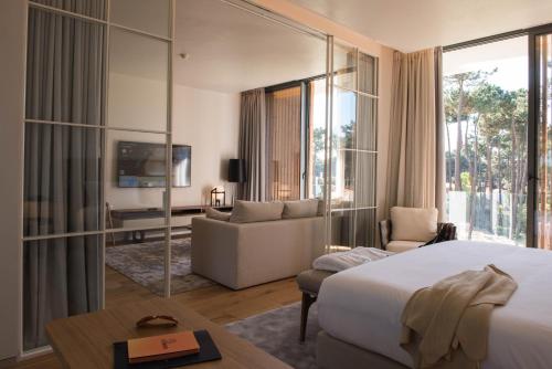 a hotel room with a bed and a living room at Aroeira Lisbon Hotel - Sea & Golf in Aroeira