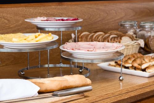 a table with several plates of food and bread at Alfa Suites - Montevideo in Montevideo