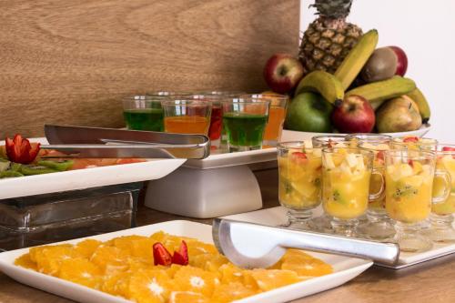 a table topped with plates of fruit and drinks at Alfa Suites - Montevideo in Montevideo