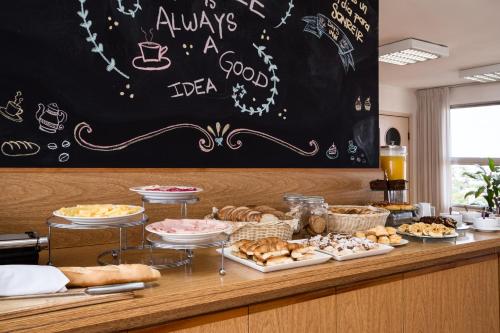 a counter with various pastries and a chalkboard at Alfa Suites - Montevideo in Montevideo