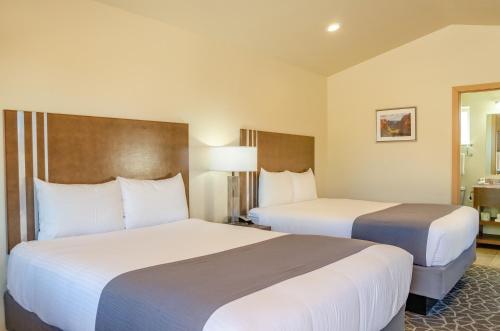 ein Hotelzimmer mit 2 Betten und einem Fenster in der Unterkunft Mountain Ridge Cabins & Lodging Between Bryce and Zion National Park in Hatch