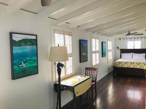 1 dormitorio con cama, escritorio y mesa en Sugar Apple Bed and Breakfast en Christiansted