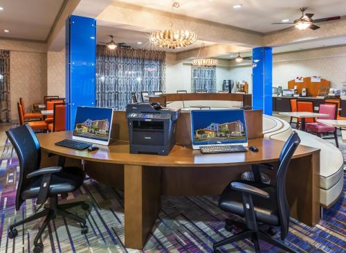 a lobby with two computers on a table with chairs at Holiday Inn Express & Suites Houston East by IHG in Houston