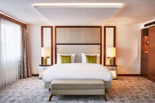 a bedroom with a large white bed and two lamps at Kempinski Hotel Corvinus Budapest in Budapest