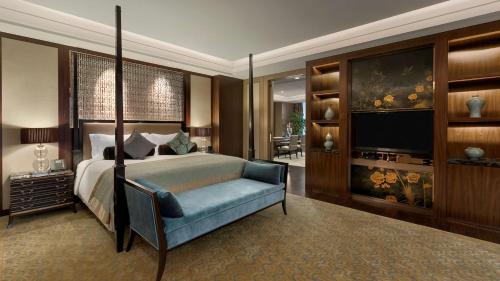 a bedroom with a bed and a tv and a couch at Kempinski Hotel Xiamen in Xiamen