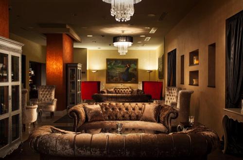 a living room with a leather couch and chairs at Royal Maxim Palace Kempinski Cairo in Cairo