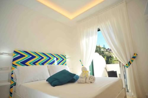 Un dormitorio con una cama blanca con un animal de peluche. en Matteo's House B&b en Amalfi