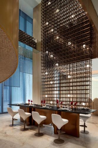 a restaurant with a bar with chairs and a large window at Kempinski Hotel Hangzhou in Hangzhou