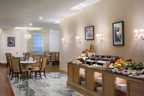 a restaurant with a buffet of food on a table at Kempinski Al Othman Hotel Al Khobar in Al Khobar