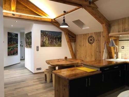 a kitchen with wooden walls and a wooden table at La Datcha du Parc in Husseren-Wesserling