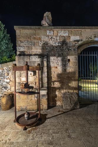 a stone wall with a gate and a shelf with pots at Masseria Cinti in Bagnolo del Salento