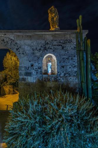 a statue of a woman in a window at night at Masseria Cinti in Bagnolo del Salento