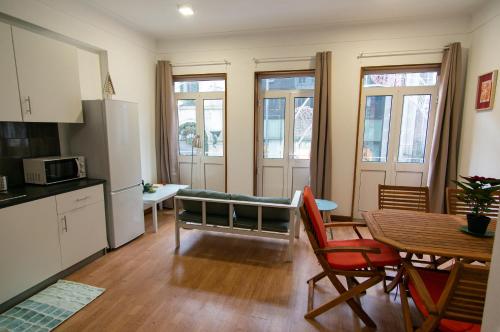 un soggiorno con cucina e tavolo con sedie di Change The World Hostels - Porto - Santa Catarina a Porto