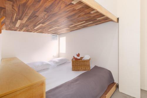 - une chambre avec un lit et un plafond en bois dans l'établissement oOstel Smart Hostel - Tulum Pueblo, à Tulum