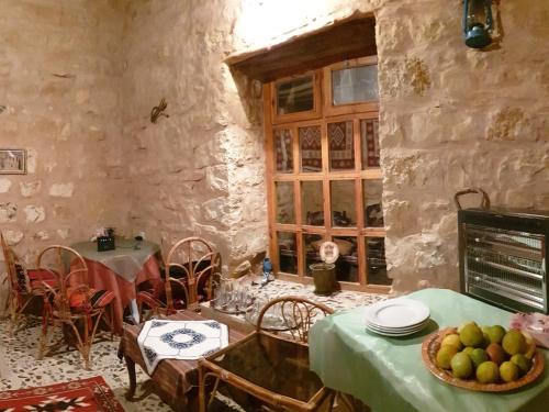 a dining room with a table with a bowl of fruit at The Orient Home in Wadi Musa