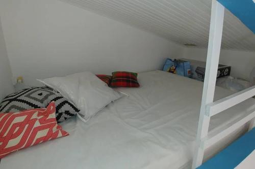 a white bunk bed with pillows on it at AnseMitan beach studio,Clim,wifi, 200mplage 3îlets in Les Trois-Îlets